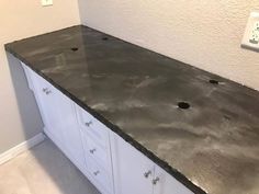 a counter top in a kitchen with white cabinets and gray marble on the counterstop