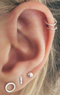 an ear with three piercings attached to it's side and two smaller ones behind the ear