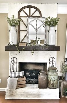 a white fireplace with some vases on top of it and an old mirror over the mantel