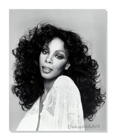 a black and white photo of a woman with long curly hair wearing a sheer top