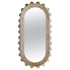 a mirror that is sitting on top of a white wall with gold trimmings