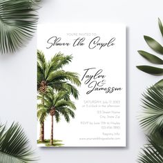 the tropical palm tree wedding card is displayed on a white background with greenery around it