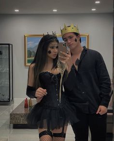 a man and woman dressed up in costumes taking a selfie with a cell phone