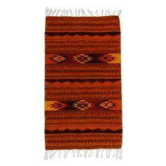 an orange and brown rug with fringes on the bottom, in front of a white background