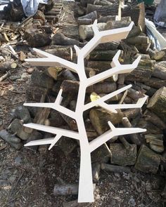 a tree made out of wood sitting on top of a pile of logs