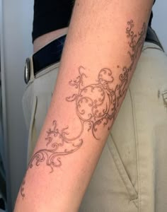 a woman's arm with a tattoo on it that has vines and flowers all over it