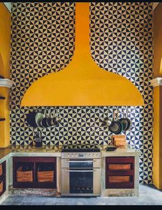 a kitchen with an oven, stove and cabinets in the wall is decorated with geometric patterns