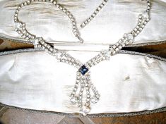 "Offering a breathtaking vintage high-end Art Deco navy sapphire blue and clear crystal rhinestone tassel/chandelier necklace. The perfect \"Something Old\" and \"Something Blue\" for the Bride! I absolutely love this necklace; photos don't begin to capture the sparkle adequately. The so Art Deco flapper treasure features a central navy sapphire blue square cut crystal rhinestones as well as brilliantly clear sparkly square and round cut crystal rhinestones. The bottom tassel creates a bit of mo Vintage Necklace With Diamond Accents For Evening, Vintage Jeweled Rhinestone Necklace For Formal Occasions, Victorian Jewelry With Rhinestones For Vintage Events, Vintage Crystal Bridal Necklace, Elegant Rhinestone Necklace For Vintage Events, Vintage Wedding Necklaces With Sparkling Stones, Vintage Rhinestone Necklace With Sparkling Stones For Wedding, Vintage Rhinestone Necklace For Wedding, Silver Vintage Bridal Necklace