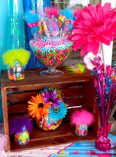 there are many colorful items on the shelf in this room, including flowers and candy