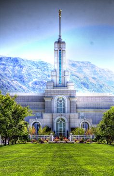 a large building with a tall steeple on top of it's side in the middle of a green field