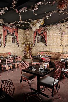 the interior of a restaurant with tables and chairs, decorated in pink and black colors