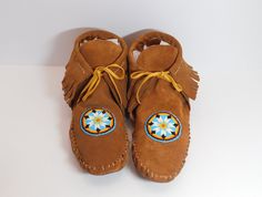 These Native American inspired fringed boot style leather moccasins with beaded rosette are one of our few listings for handmade moccasins that are made to order. We offer different size variations and this listing is for the color leather in the picture. Orders for this item are filled on the first come first served basis. It takes us time to hand trace the pattern, hand cut the leather, glue the insoles in and hand stitch the moccasins. We do not use a machine to do any portion of our moccasins we do it all by hand. It also will take approximately 7-9 days for shipping to you. We use premium suede moccasin leather to make them. Currently the only moccasin style we make is the ankle boot moccasin with the fringe around the heel. We make each and every pair to order, with the occasional pa Native American Moccasins, Handmade Moccasins, Leather Glue, Beaded Moccasins, Moccasins Women, Cosplay Boots, Moccasins Style, Moccasins Mens, Native American Style