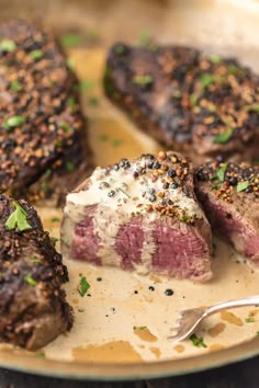 some steaks are on a plate with sauce and seasoning sprinkles