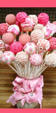 a bouquet of pink and white chocolate covered candies in a vase on a table