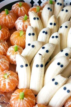 bananas and oranges are arranged in the shape of ghost faces, with black dots on them