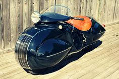 a black motorcycle parked on top of a wooden deck