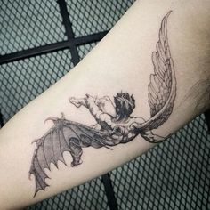 a tattoo on the arm of a man with an angel and demon flying over it