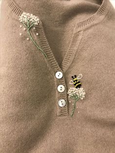 a sweater with buttons and flowers on it