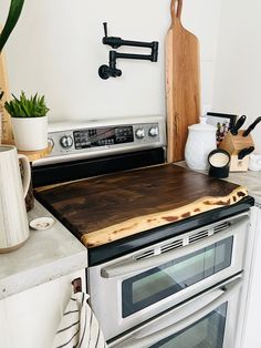 a kitchen with an oven, cutting board and utensils on the counter top