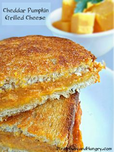 two grilled cheese sandwiches sitting on top of a white plate