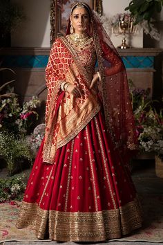 a woman in a red and gold bridal gown