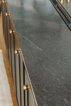 a black counter top with gold knobs on it