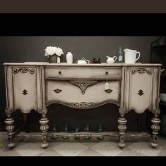 an antique style buffet table with drawers and knobs