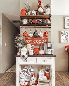 a white table topped with lots of orange and white items next to a shelf filled with coffee mugs