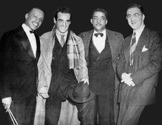 four men in suits and ties are posing for a photo with one man holding a cane