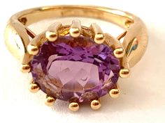 "Vintage 14K Yellow Gold & 7ct Amethyst Ring Statement Ring The center of this gorgeous ring is set with oval violet purple natural Amethyst. Band stamped \"14K\" and \"China\" Box is included with this ring. Condition: Very good vintage condition. Gold is bright and shiny. Amethyst is in good shape. Ring Size: 7. Ring measure: 0.4\" (10mm) top to bottom, 0.6\" (16mm) side to side, 0.3\" (8 mm) rise above finger, 2mm band width at the center back. Amethyst: oval shape, faceted, measuring approx. 15 mm x 10 mm x 8 mm. Ring weight: 6.83 grams" Luxury Yellow Gold Victorian Amethyst Ring, Purple Oval 14k Gold Gemstone, Oval Amethyst Ring In Yellow Gold, Luxury Oval Solitaire Amethyst Ring, Solitaire Amethyst Ring In Yellow Gold, Oval Shape, Oval Purple Sapphire Ring In 14k Gold, Purple Amethyst Solitaire Ring In Oval Shape, Oval Solitaire Amethyst Ring In Yellow Gold, Purple Solitaire Amethyst Ring, Oval Shaped