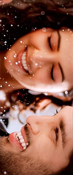 a man and woman laying down next to each other in the water with bubbles all over them