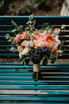 a bouquet of flowers sitting on top of a blue bench