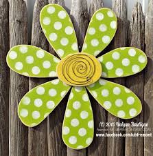 a green flower with white dots on it sitting next to a wooden fence and wood slats