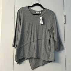 Round Neck, 3/4 Sleeves With Raw-Cut Crossover. Detailing At Front And Back With Asymmetric Hem. Cotton. Relaxed Fit Half Sleeve Top For Layering, Versatile Tops For Layering With 3/4 Sleeves, Casual Gray Tops With 3/4 Sleeve, Spring Versatile Tops With 3/4 Sleeves, Gray 3/4 Sleeve Tops For Fall, Gray Half Sleeve Tops For Spring, Gray 3/4 Sleeve Summer Top, Gray 3/4 Sleeve Top For Summer, Gray Summer Top With 3/4 Sleeves