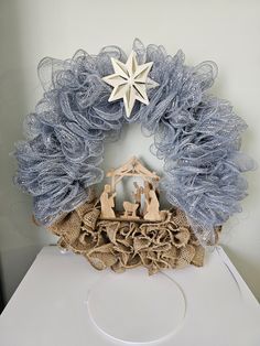 a nativity wreath with a star on top and burlap around it, sitting on a table