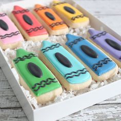 a box filled with decorated cookies sitting on top of a table