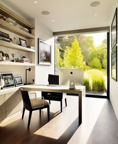 a home office with large windows and wooden flooring