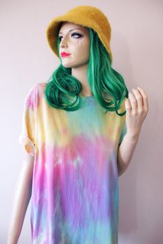 a mannequin with green hair wearing a yellow hat and tie dye t - shirt