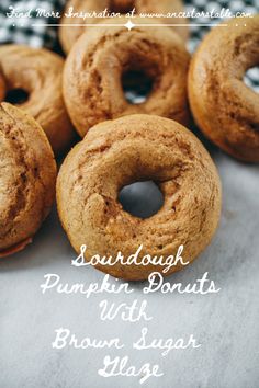 there are several doughnuts on the table with words above them that read, sourdough pumpkin donuts with brown sugar glaze