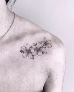 a black and white photo of a woman's chest with flowers on it