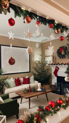 a living room decorated for christmas with ornaments hanging from the ceiling