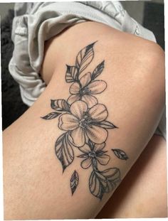 a woman's thigh with flowers and leaves on it