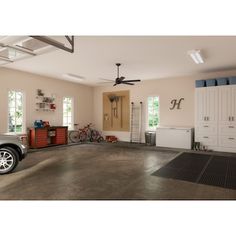 a car is parked in a garage with other cars and cabinets on either side of the garage door