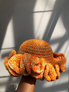 an orange and white hat on top of a hand