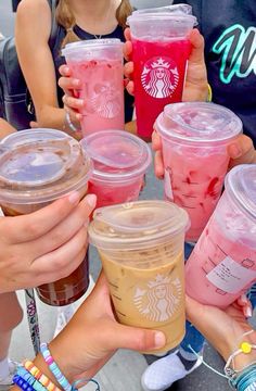 many people holding up cups with drinks in them