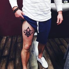 a man with a fleur de lis tattoo on his leg