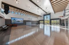 an indoor basketball court with hard wood floors and large windows on the wall, along with hardwood flooring