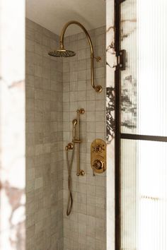 a shower head and hand held shower faucet in a bathroom with white tile walls