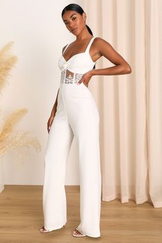 We're head over heels for the modern loveliness of the Lulus Adore the Feeling White Sheer Lace Bustier Twist-Front Jumpsuit! Stretchy, crepe-knit fabric shapes this sophisticated and sexy jumpsuit that has wide tank straps and a fitted bodice with a twist-front detail. Sheer, bustier-inspired panel wraps the bottom of the bodice, with gorgeous applique lace and seaming details. Pants have a flattering silhouette with wide legs that fall to ankle-length hems. Hidden zipper/clasp at back. Fit: Th Fitted Jumpsuit With Sweetheart Neckline For Date Night, Elegant Jumpsuits And Rompers With Sweetheart Neckline For Party, Elegant Jumpsuits With Sweetheart Neckline For Night Out, Chic Fitted Jumpsuits With Sweetheart Neckline, Chic Fitted Jumpsuit With Sweetheart Neckline, Chic Fitted Jumpsuits And Rompers With Sweetheart Neckline, Fitted Summer Jumpsuits And Rompers With Sweetheart Neckline, Spring Wedding Fitted Jumpsuits And Rompers, Glamorous Spring Wedding Jumpsuit Or Romper