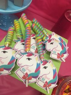 there are many candy sticks on the table with unicorn stickers in front of them